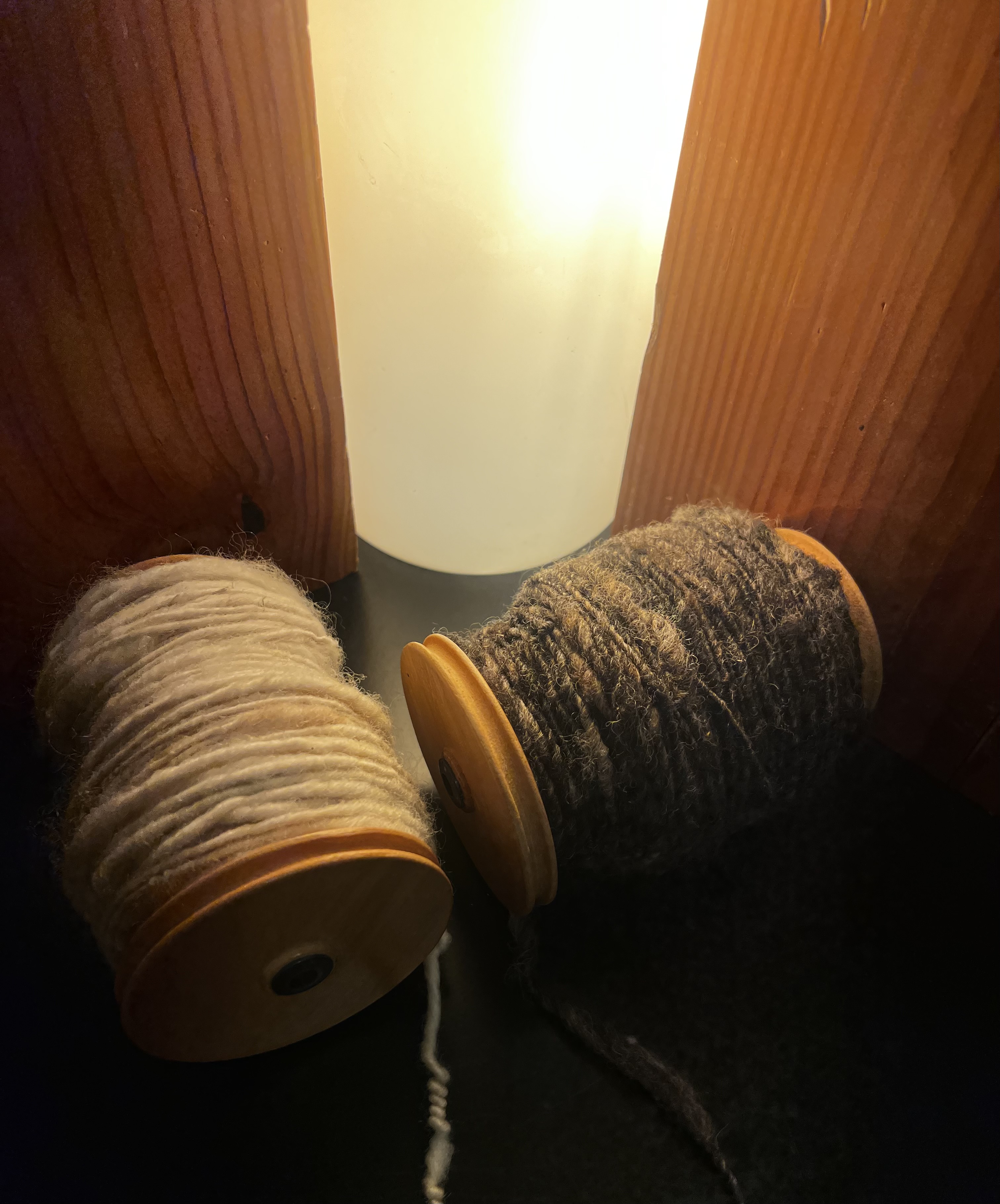 two spindles wrapped with yarn